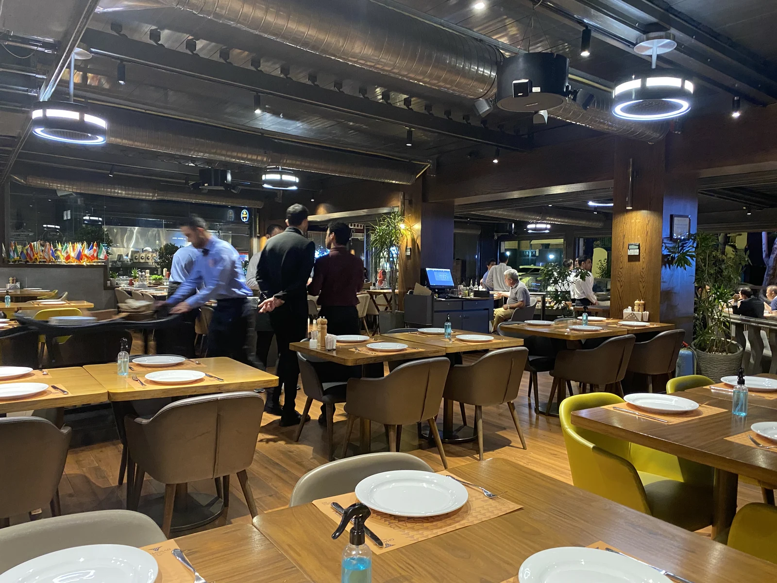 Several black dp air purifiers above restaurant tables